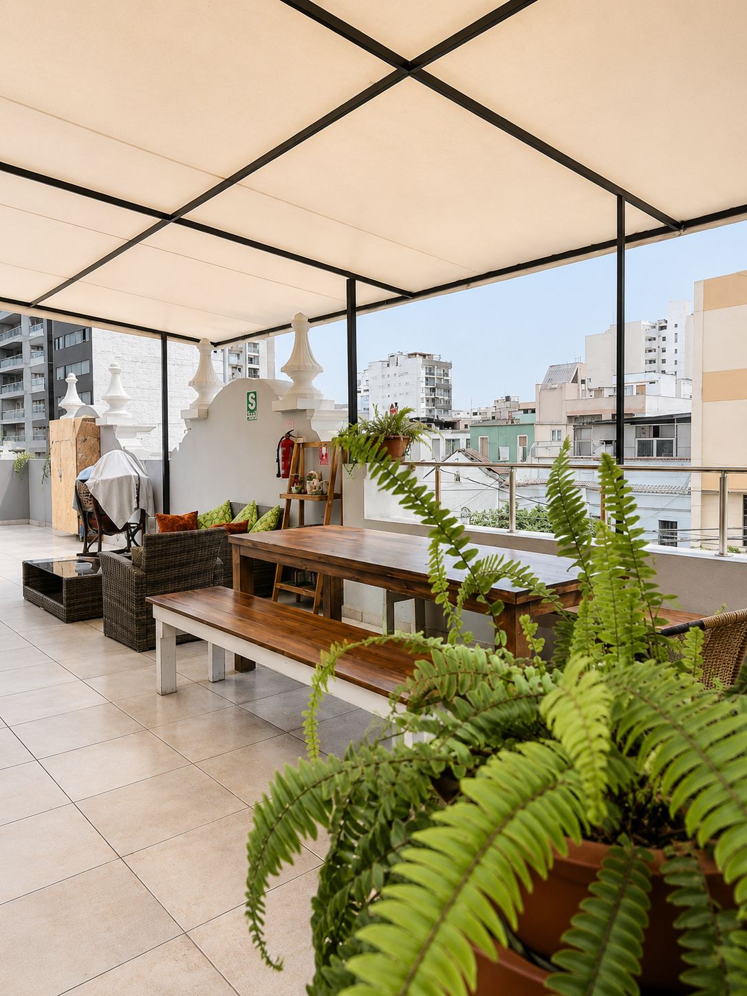 Terraza techada con mesa larga y vista a Miraflores